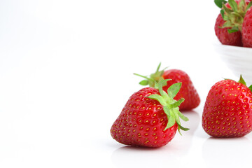 Red ripe strawberry in the white bowl, isolated
