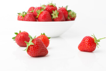 Red ripe strawberry in the white bowl, isolated