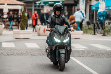 Fototapeta premium A modern motorcyclist drives on a motorcycle on the road in the city.