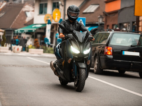 A modern motorcyclist drives on a motorcycle on the road in the city.