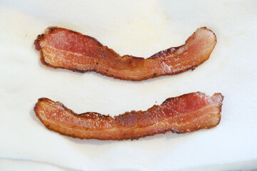 Two crispy savory pieces of bacon ready for breakfast