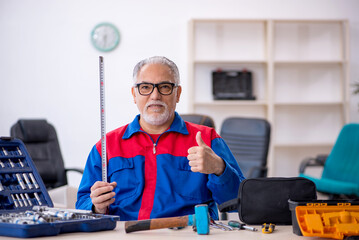 Old male repairman working at workshop