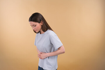Photo of mature woman unwell stomach ache infection poison spasm unhealthy isolated over beige...