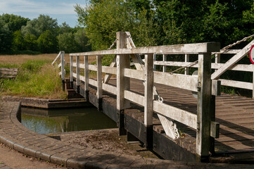 Fototapeta na wymiar wooden turning manual foot bridge over the river canal