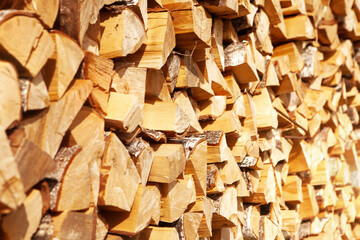 Chopped firewood stacked in a woodpile, for kindling a stove or fireplace, for heating a house. Concept of economic fuel crisis.