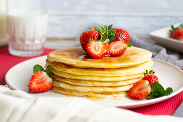 Delicious pancakes with strawberries and honey