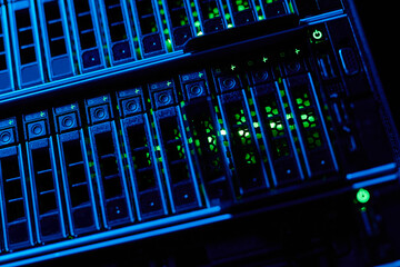 Close up background image of blade servers in blue neon light stacked in data center, copy space