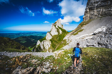 Fototapeta premium Hiker is descending on trail with a beautiful panorama