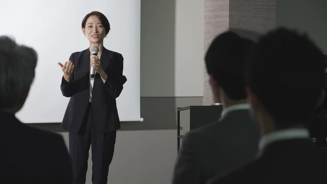 セミナーでプレゼンをするビジネスウーマン