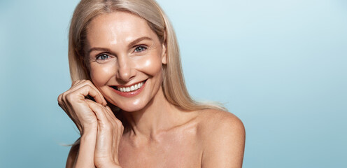 Elegant middle aged woman, head and shoulders with glowing skin, nourished, moisturized face and...