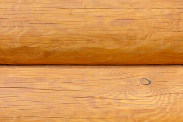 Facade of a pine log house, wooden background, close-up.