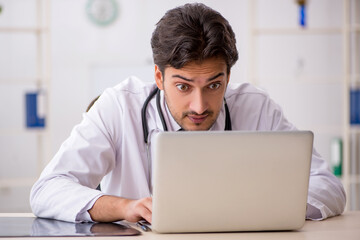 Fototapeta premium Young male doctor in telemedicine concept
