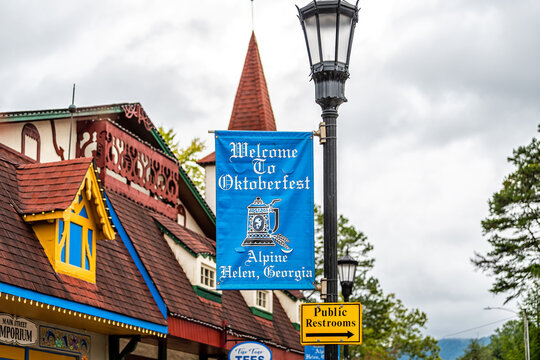 Helen, USA - October 5, 2021: Bavarian village of Helen, Georgia with welcome sign for famous Oktoberfest festival in fall season with tower architecture in background on cloudy day