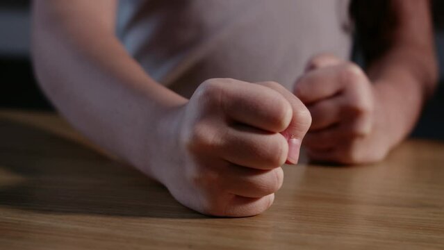 Close up Fist of angry child beats on the table in slow motion. Little kid girl angry.