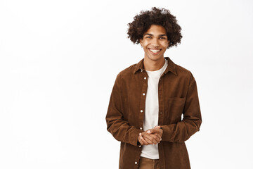 Smiling queer guy with afro hairstyle, looking happy, he is ready to help, answer your questions,...