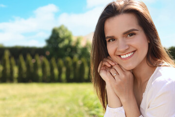 Portrait of beautiful young woman at backyard, space for text