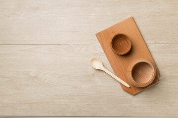 Wooden bowls and board on wooden background, top view