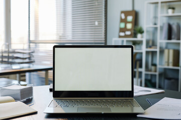 Background image of mock up computer with blank white screen in empty office interior, copy space