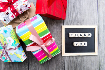 Fototapeta premium gifts in colorful boxes with ribbons and an inscription from THANK YOU cubes.