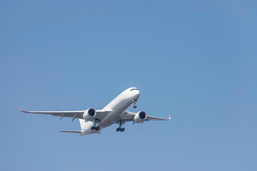 青空を背景に羽田空港に着陸態勢に入る飛行機