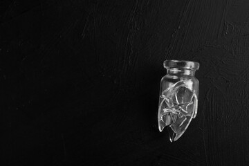 frasco de vidrio roto sobre fondo negro con textura, vidrio roto, pedazos de vidrio regados