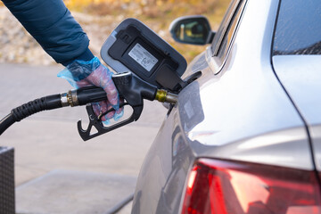 Fuel price in Europe. Refueling the car.Refueling pistol in the hands of a man in a blue glove.Car...