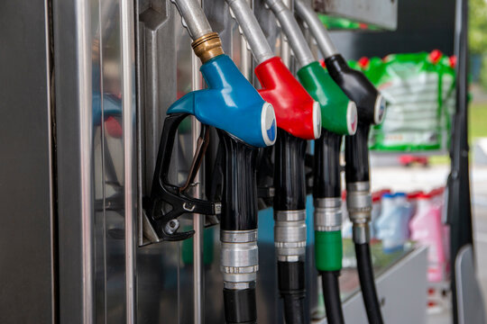 Petrol pump filling nozzles at gas station. Blue, red, green, black color fuel gasoline dispenser background