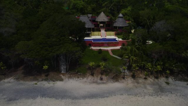casa con alberca en una playa virgen desde un dron 