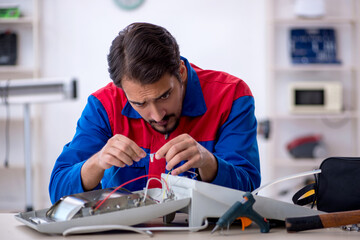 Young male repairman repairing heater