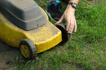 mowing the grass with an electric mower by a person