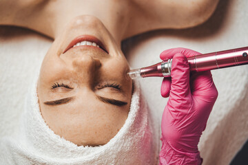Close-up portrait of woman getting facial hydro microdermabrasion peeling treatment at spa clinic....