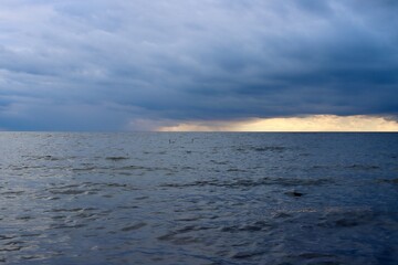 Heavy weather front over Baltic sea, calm blue sea, dark clouds