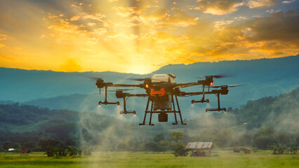 smart farming innovation, agriculture drone fly spraying fertilizer on green rice field in...