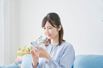 リビングでスマホで使う女性