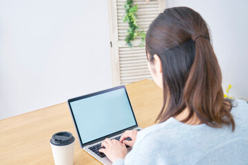 リビングでノートパソコンを使う女性