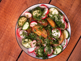 Baked potatoes with vegetables and dill on a colored plate