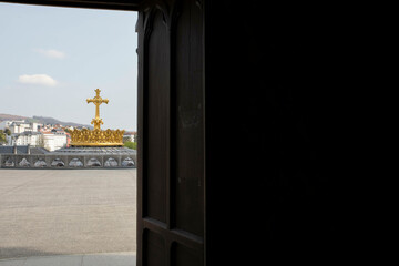 View of the gold crown and cross from inside Our Lady of Lourdes in France, Europe