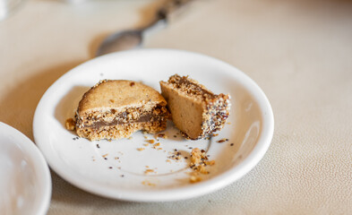 Close up of a typical homemade Argentinian alfajor filled with dulce de leche and covered with seeds on a white plate. Argentina is the world’s biggest producer and consumer of this sweet. 