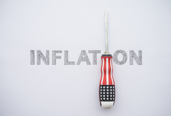 Word hand writing INFLATION and US flag screwdriver on white paper background copy space. The...