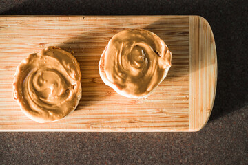healthy plant-based food, peanut butter on freshly toasted English muffins on bamboo cutting board