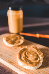 healthy plant-based food, peanut butter on freshly toasted English muffins for breakfast with kitchen bokeh