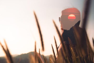 Young woman at sunrise sky in the nature.