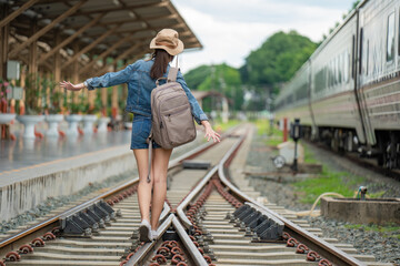 Asian woman balancing on the train rail.  Attractive young woman walking outdoors.