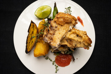 fried fish with rosemary, accompanied by sweet potato, lemon and different French sauces