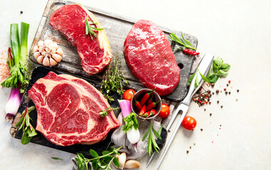 Variety of raw beef meat steaks for grilling.