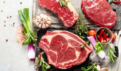 Variety of raw beef meat steaks for grilling.