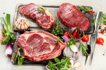 Variety of raw beef meat steaks for grilling.