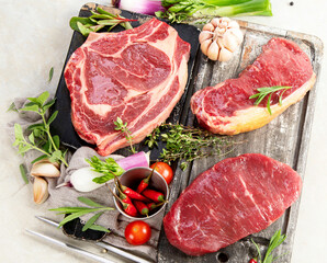 Variety of raw beef meat steaks for grilling.