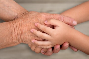 Support hands. young woman holding a senior man's hands in comfort. Female carer holding hands of senior man