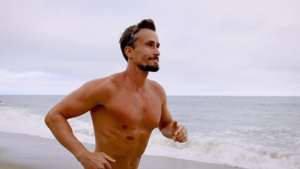 Athletic man jogging at the beach in Southern California. Slow Motion.